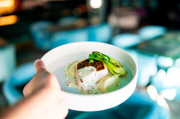 hand hold Fried fillet dorado fish with mushed potato and sauce