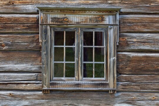Closeup of a old wooden window on a wooden weathered wall.