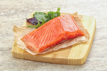 Raw salmon fillet over board