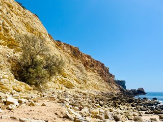 Rocky coast of the ocean bay, clear blue sky, ocean horizon, rocks
