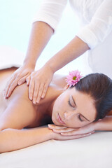 Calm, massage and woman at wellness spa with flower for health, relax and luxury holistic treatment. Self care, peace and girl on table with masseuse for body therapy, balance and hotel service.