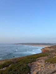 Rocky coast of the ocean bay, clear blue sky, ocean horizon, rocks