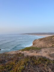 Rocky coast of the ocean bay, clear blue sky, ocean horizon, rocks