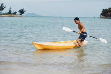 Happy Asian Man Paddling a Kayak in Tropical Adventure