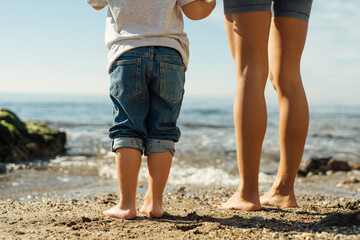 mother and son holding hands on the seashore. psychology of communication with children. family sea...