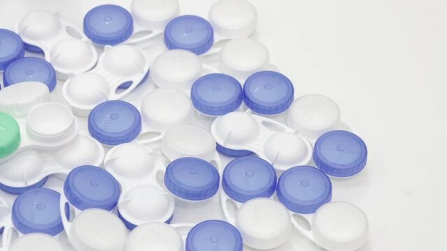 Several contact lens cases are placed on a white table.