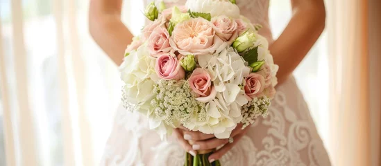 Gardinen The bride holds a luxurious white wedding bouquet in pastel shades with roses, carnations, and hydrangeas. © Vusal