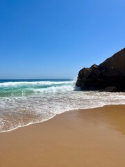 Rocky coast of the ocean bay, clear blue sky, ocean horizon, rocks