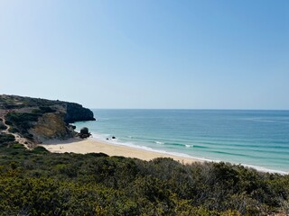 Rocky coast of the ocean bay, clear blue sky, ocean horizon, rocks