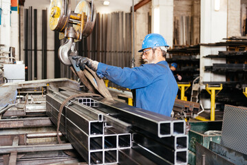 Man working with hydraulic crane metal beams construction workshop at factory