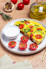 Frittata with tomatoes and spinach. Italian cuisine. Vegetarian food.