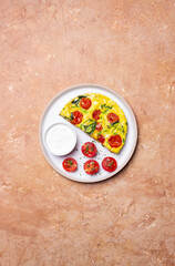 Frittata with tomatoes and spinach. Italian cuisine. Vegetarian food.