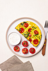 Frittata with tomatoes and spinach. Italian cuisine. Vegetarian food.