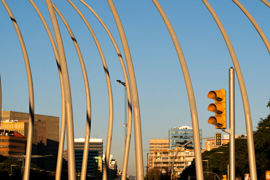 Yellow traffic light at an intersection in the middle of a cityscape in a modern financial area