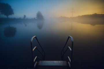stairs into lake at night with fog. High quality photo