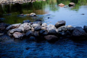 Abstract background stream of water, Waterfall stream on rocks, Rocky riverbank, Calm water stream around the rocks, Stream