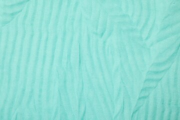 Texture of turquoise crumpled fabric as background, top view