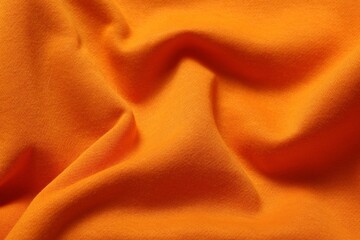 Texture of orange crumpled fabric as background, top view