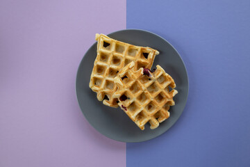 Top view of two Belgian waffles with blueberries.