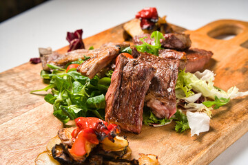 Grilled rack of lamb on a cutting board. Hot rack of lamb with spices and seasoning. Top view on wooden table.