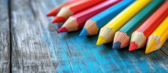 Pastel color pencils on a wooden desk convey an open house message for education or school purposes.