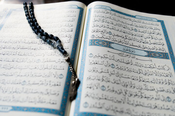 Tasbih or rosary beads over Holy Qur'an text.