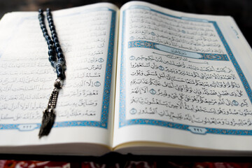 Tasbih or rosary beads over Holy Qur'an text.