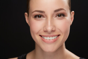 Obraz premium Model, happiness and portrait in studio with cosmetics, closeup and beauty results of cosmetology in mockup. Woman, face and skincare with retinol for glow, facial and make up on black background