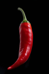 Vivid Red Chili Pepper Isolated on Black Background: Symbol of Spice and Flavor