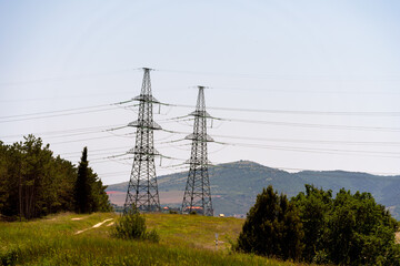 High voltage towers Electric pole. Power line support with wires for electricity transmission. High voltage grid tower with wire cable at distribution station. Energy industry, energy saving