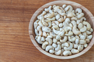 Cashews in a wooden bowl. Nuts are healthy food. Wooden background. Cashew kernel