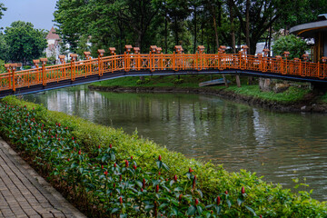 beautiful orange bridge with flowing river in city park.