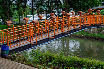beautiful orange bridge with flowing river in city park.