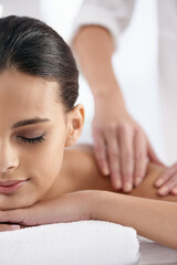 Relax, woman and hands massage shoulder for skincare, beauty and pampering body for wellness at luxury salon. Therapist, table and person at spa for treatment, peace and calm for health with masseuse