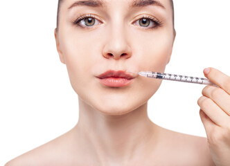 Young woman gets cosmetic injection in lips.