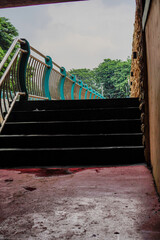 close view of the stairs leading to the garden with the fence dividing the river.