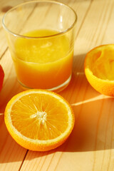  Fresh ripe  oranges  and glass of juice on wooden background   