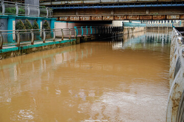 river water flowing fast after the rain with dirty brown water.