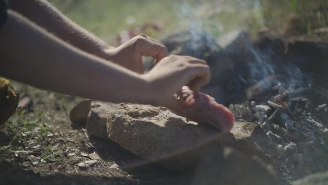 Prehistoric man cooks meat on the village fire