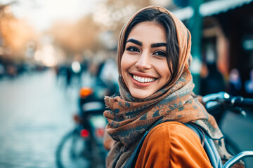 Charming young middle eastern muslim woman wearing a hijab posing and smiling at a city streets.