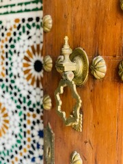 Metal doorknob and pull handle mounted on a wooden door frame