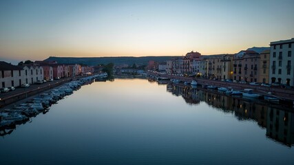 Fototapeta premium Beautiful view of colorful houses on the waterfront with docked yachts at scenic sunset
