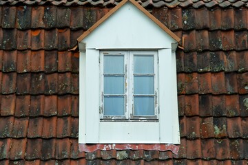 Fototapeta na wymiar Classic, white window frame on the side of a weathered old brick wall