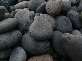 Fototapeta na wymiar Closeup of a pile of beautiful dark grey big and small stones