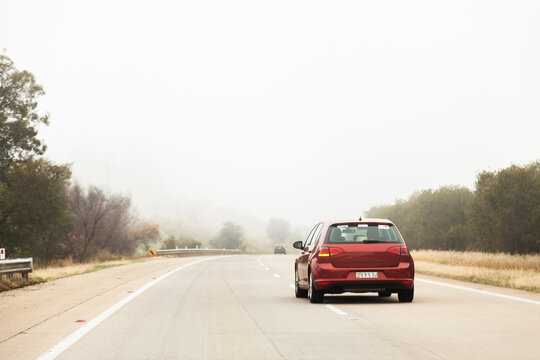 Fototapeta Red car overtaking in the right hand lane in foggy conditions