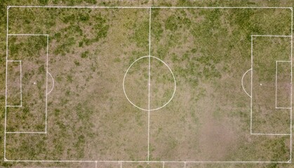 Top view on a soccer pitch with deteriorated grass surface