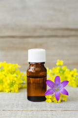 Small bottle with essential oil. Aromatherapy and herbal medicine concept. Old wooden background. Copy space.