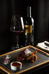 Succulent grilled beef steak with red wine, seasonings, fresh rosemary and grilled vegetables on...