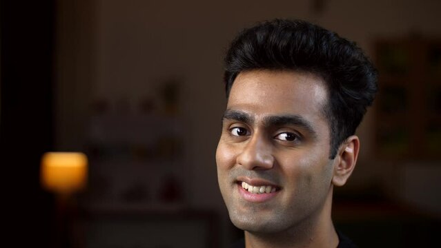 A young smart man posing for the camera with a smiling face - happy facial expression  wheatish skin  brown man. Happy confident Indian man - oral care  white teeth  healthy jaw
