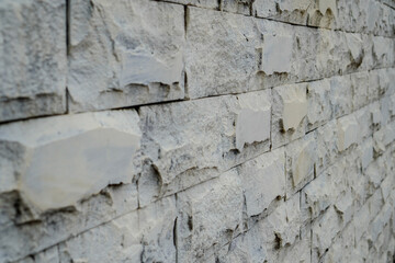 Close up view of the gray natural stone textured building wall.